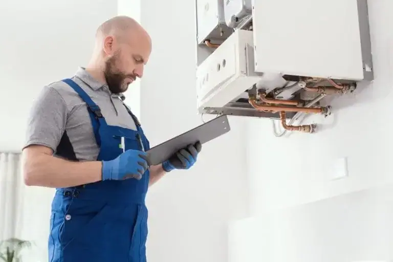 Installateur mit Prüfprotokoll vor einer geöffneten Baxi Gastherme